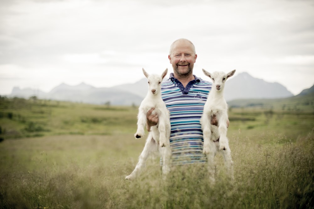 Mann som løfter to geiter