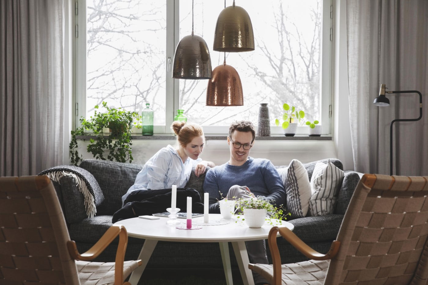 par i sofa, mann og kvinne, ser på samboerkontrakt