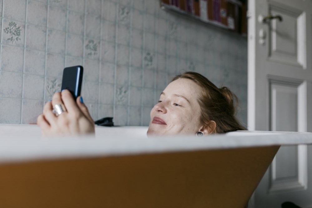 Dame slapper av og leser på mobilen.